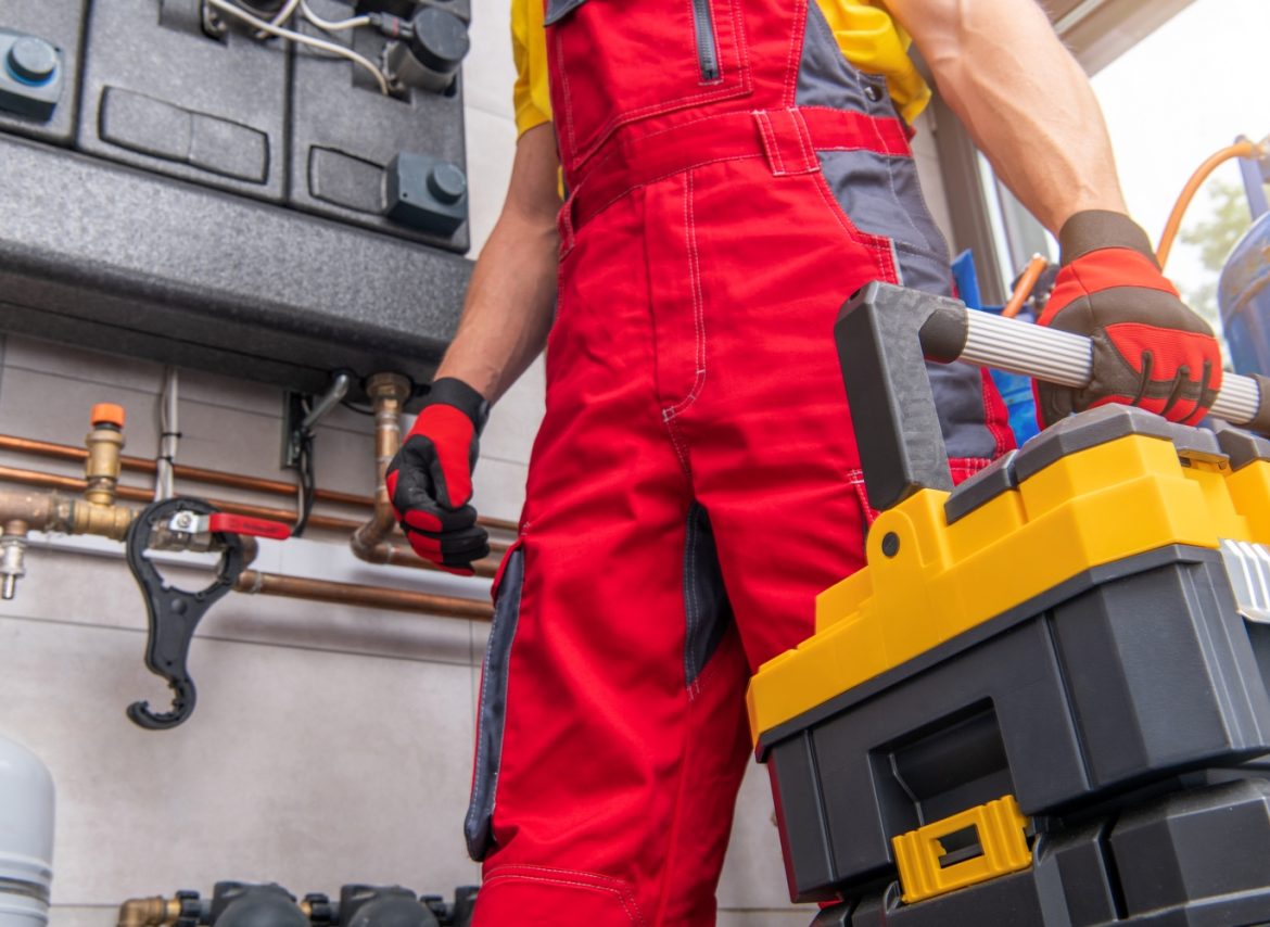 Heating Ventilation and Air Condition Technician with His Toolbox Finishing His Scheduled Maintenance.