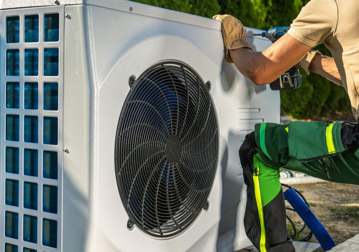 Caucasian HVAC Worker Installing Electric Modern and Energy Saving Heat Pump.