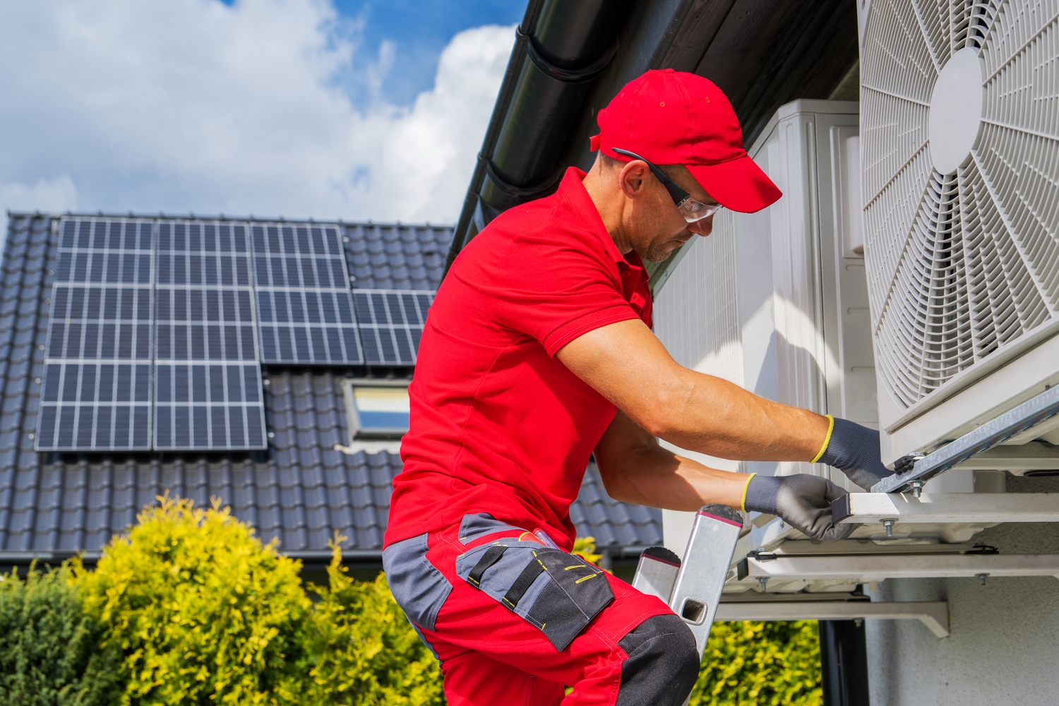 HVAC Worker Performing Heat Pump Maintenance. Device is Transferring Thermal Energy From the Outside Using the Refrigeration Cycle. Home Heating Technologies.